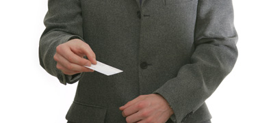 Person in a suit holding out a white card