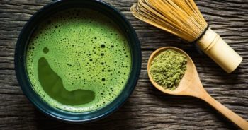 set-up of matcha powder beside a wooden spoon and whisk- do matcha case study - out-smarts marketing