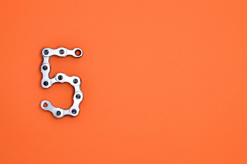 Orange background with a metal number '5'