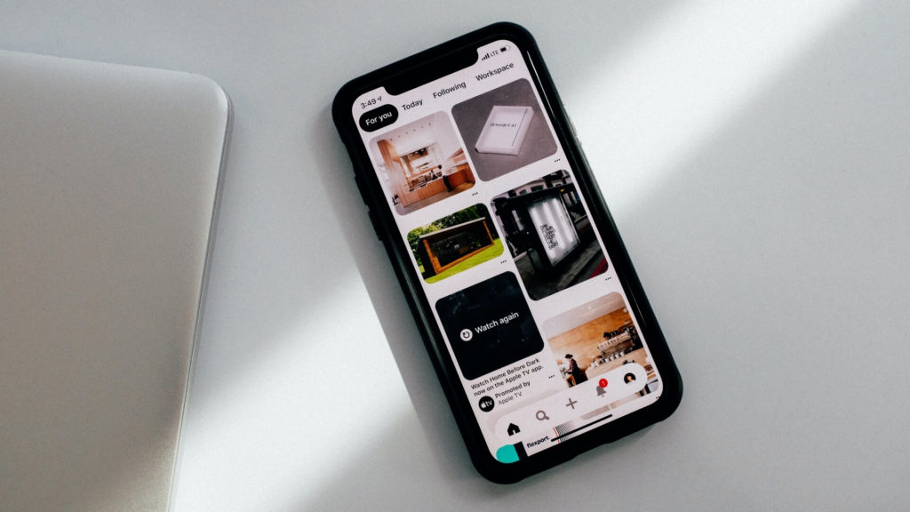Pinterest open on a phone on a white desk